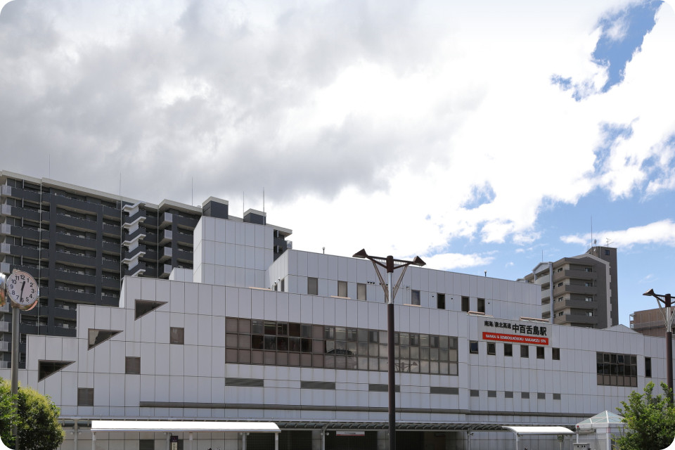 白色タイル張りの介護施設の建物外観。複数階建てで周辺住宅街に立地。